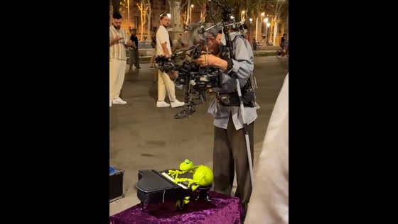 Old man busks in Barcelona with a puppet playing piano