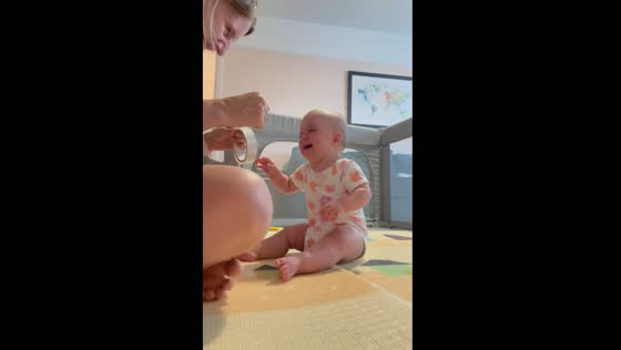 Child laughs hysterically at sound of unrolling tape