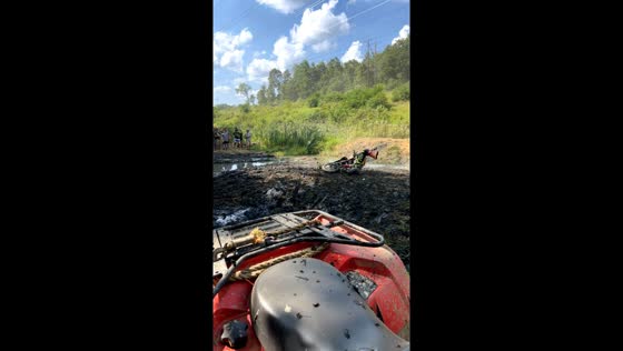 Motorbike riders attempt creek jump at Powerline Park during AWRCS racing