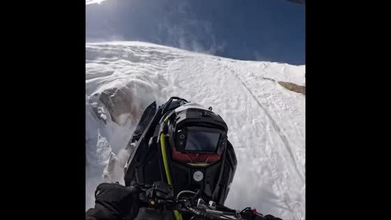 Snowmobile mishap on mountain slope in Laramie, Wyoming, USA