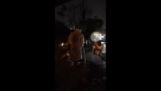 Riders help pull car from canal edge during heavy rain in Manila, Philippines