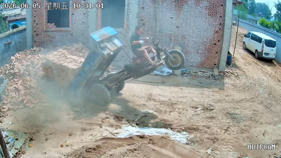 Overloaded flatbed e-bike tips backward while unloading bricks in Henan, China