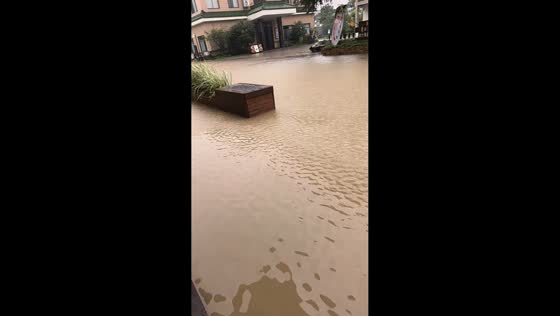 Muddy floodwaters cover street and building in Jiangsu, China