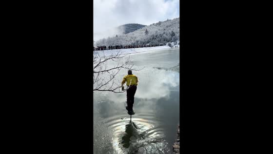 Rider glides across winter lake on hydrofoil scooter in Zhejiang, China