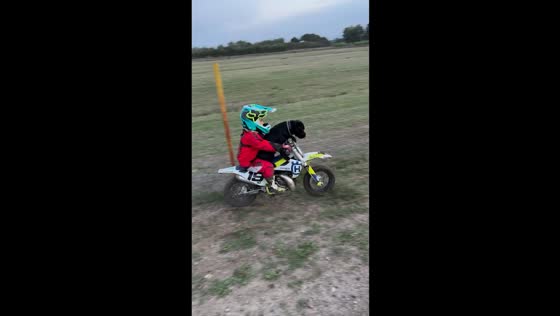 Boy and Staffordshire Bull Terrier ride mini motocross bike in Sardegna, Italy