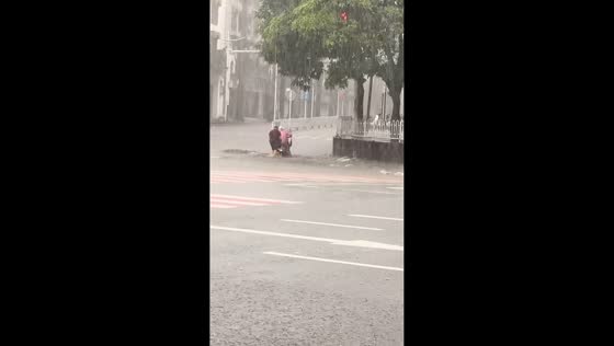 Driver helps stranded rider during flash flood in Mangshi, China