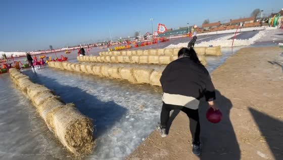 Man dodges bowling ball only to slip on frozen lake in Liaoning, China