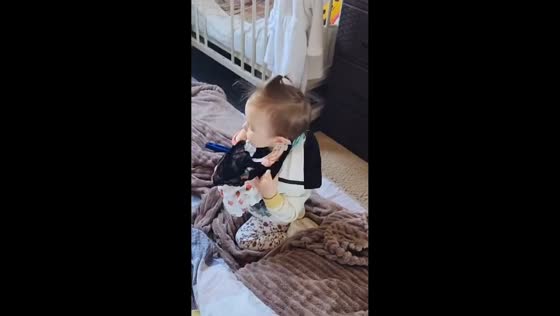 Toddler plays dress-up with scattered clothes in Vladivostok, Russia