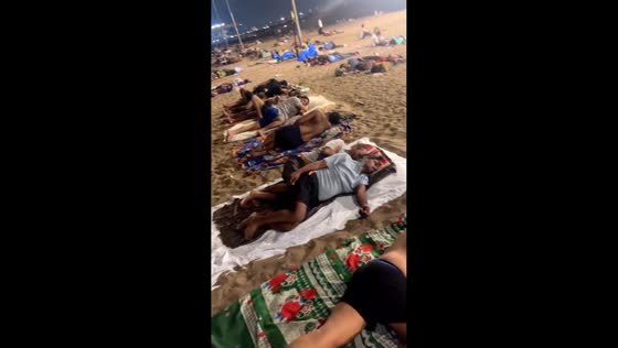 Hundreds rest on Versova Beach amid heatwave and power outages in Mumbai, India