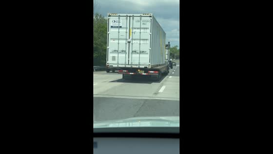 Loose shipping container sways on semi-truck highway in New Jersey, USA