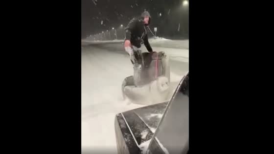 The rider turned the chair into a snowboard and drove it down the road.
