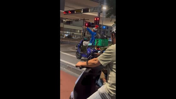 Delivery rider dances at traffic light in Jiangsu, China