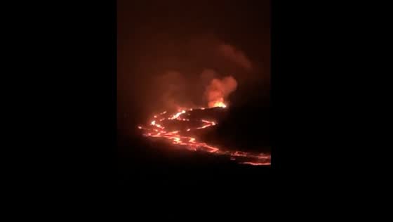 The flowing lava of Mauna Loa's illuminates the darkness of the night.