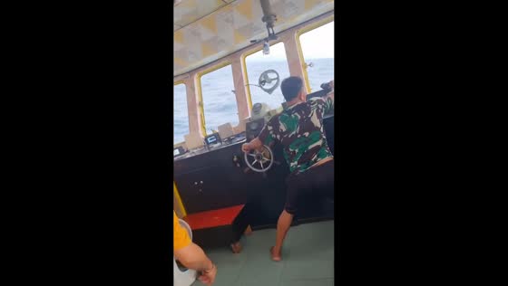 Boat struggles against strong waves in Palu, Sulawesi, Indonesia