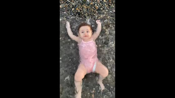 Baby gently lifted by wave on the shore in İzmir, Turkey