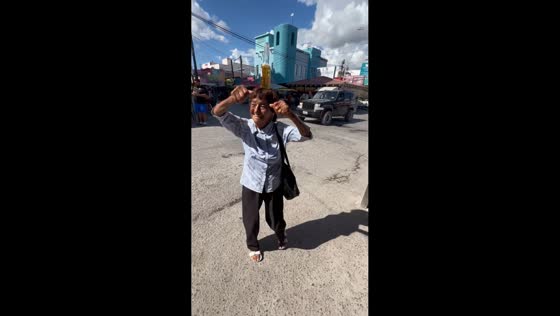 Elderly woman dances while balancing a beer bottle on her head in Nuevo Progreso, Mexico