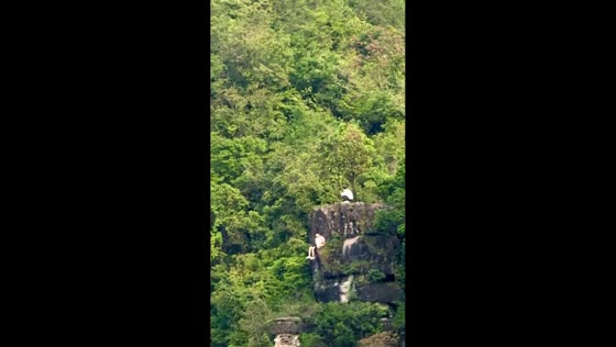 People sit on cliff edge in Hubei, China