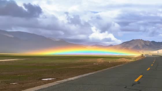 Low-hanging rainbow appears near mountains in Tibet, China