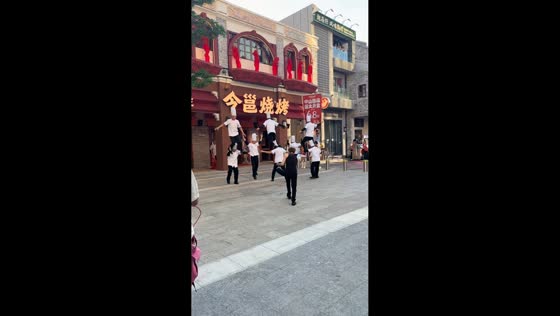 Restaurant staff perform synchronized dance outside barbecue shop in Nanning, Guangxi, China