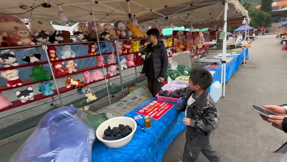 Boy succeeds in carnival-style throwing game in Guizhou, China
