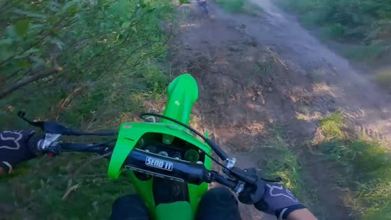Motorbike slips on muddy slope during uphill ride in Baldwin, Michigan, USA
