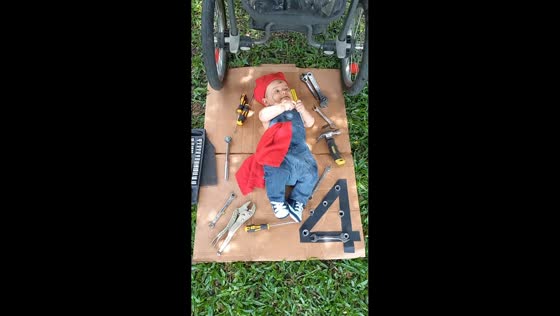 Baby dressed as a mechanic pretends to fix stroller in El Cerrito, Colombia