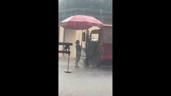 Couple shares umbrella during heavy rain in Sichuan, China