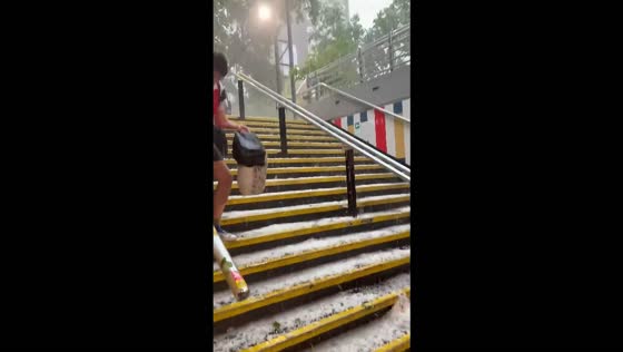 Commuter slips on hail-covered stairs at Salvador Metro Station in Santiago, Chile