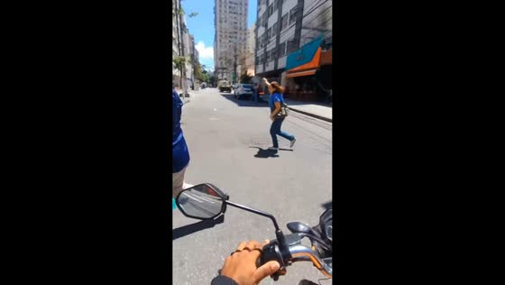 Motorcycle turn briefly startles pedestrians at crosswalk in Niterói, Brazil