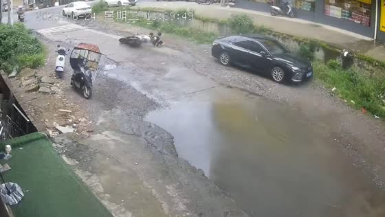 Motorcycle crashes into parked car while avoiding puddle in Hunan, China