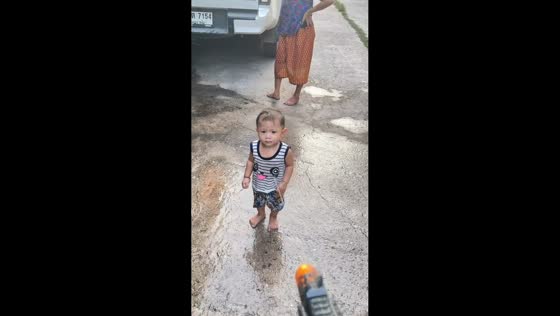Unfazed boy ignores water gun prank during playtime in Korat, Thailand