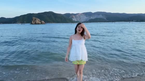 Woman loses balance and falls into water on shore in Wanning, China