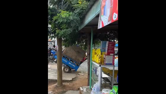 Overloaded tricycle tips backward on slope in Accra, Ghana
