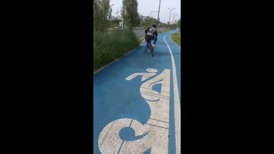 Cyclist rides unusual misaligned bicycle on pathway in Sichuan, China