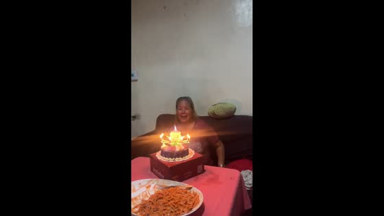 Grandmother surprised by lotus flower candle in Balasan, Philippines