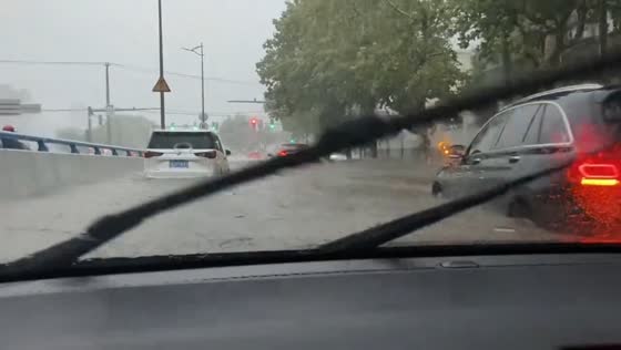 Cars struggle through flooded highway after heavy rain in Shanghai, China
