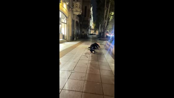 Siblings slip and fall on wet pavement in Tbilisi, Georgia