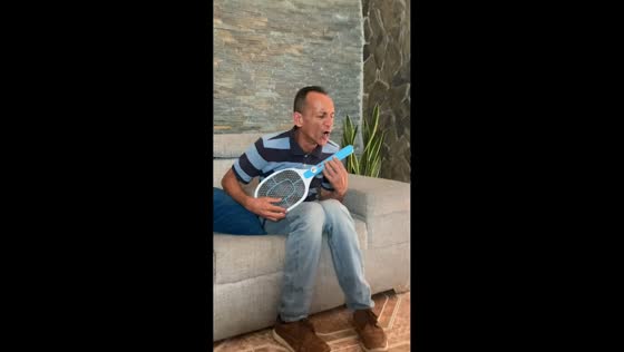 Uncle shocks himself playing electric fly swatter like a guitar in Caracas, Venezuela