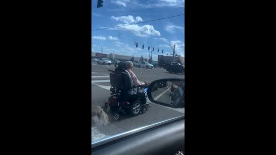 Elderly woman rides mobility scooter in Tampa traffic