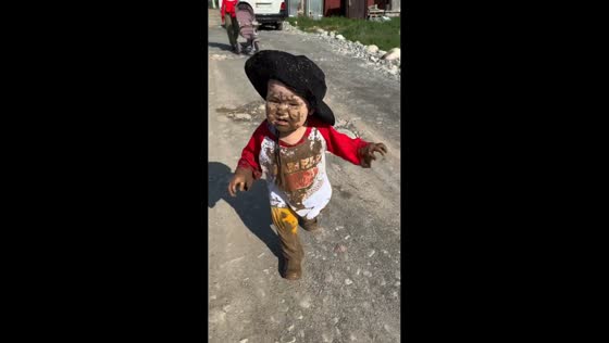 Muddy little boy enjoys carefree moment outdoors in Bishkek, Kyrgyzstan