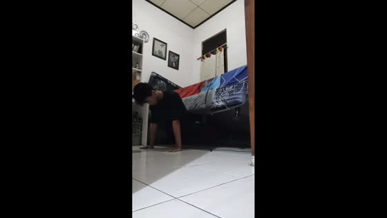 Man attempts push-ups with heavy mattress in Depok, Indonesia