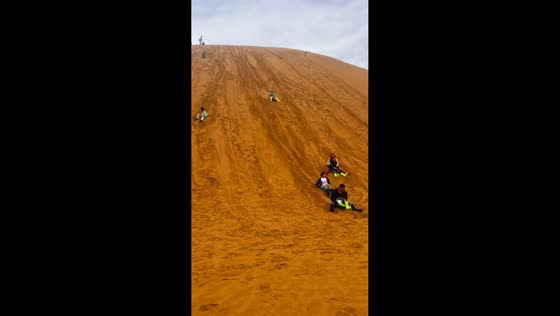 Woman takes an unexpected tumble while sandboarding in Gansu, China