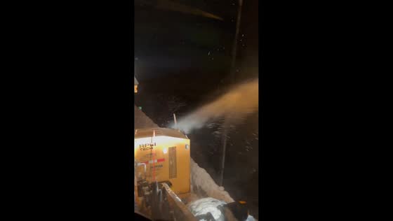 Nighttime snowblower operation clears heavy drifts along I-86 in Great Valley, New York, USA
