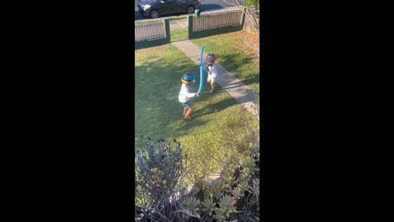 Boys playfully duel with pool noodles in Brisbane, Australia