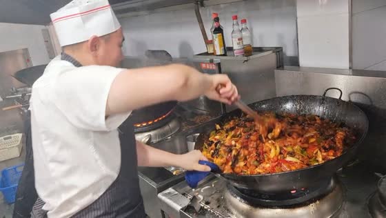 Chef’s exaggerated wok shaking during huge cooking in Jilin, China