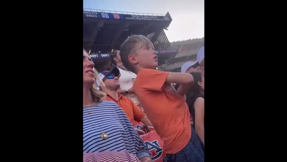 Excited boy throws shirt during football game in Auburn, Alabama, USA