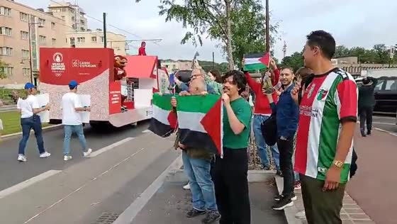Protesters in Le Plessis-Robinson wave Palestinian flags as Olympic flame passes