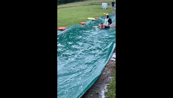 Child and dog dash down homemade 60m slippery slide