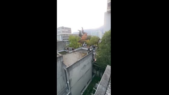 Daring double sideflip over 16 ft roof gap at GREJAM parkour event in Grenoble, France