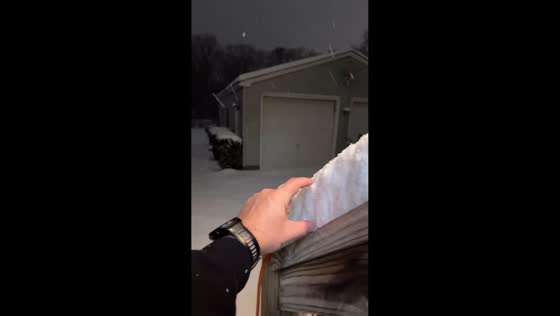 Man measures deep snow with bare hand as winter storm sweeps Virginia, USA